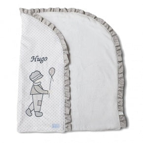 Envuelve y arropa a tu bebé con nuestro exquisito arrullo confeccionado en doble capa de 80 x 68cm. Destaca su dulce diseño, con nuestro maravillo muñeco ¨niño¨en patch, en distintas telas en tonos gris sobre el piqué de color blanco con punto gris, con volante en gris punto blanco, que además, puedes personalizar con su nombre. El interior va en suave coralina y le da un tacto muy suave y agradable. IVA Incluido en Precios.